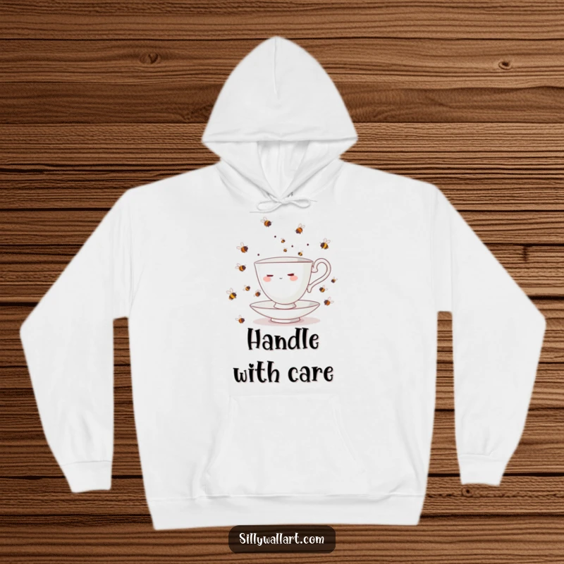 Funny teacup character juggling a swarm of bees, depicted on a cozy hoodie, offering warmth and humorous relatability.