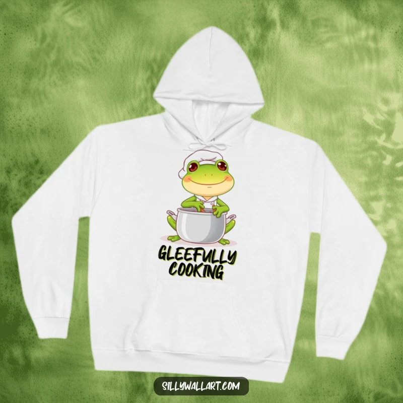 Funny hoodie showcasing a joyful frog chef cheerfully stirring a pot with a mischievous glint, a symbol of warm, playful joy.